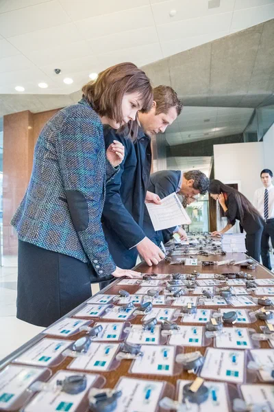 Attendees lean over a long registration table to collect name badges, captured with the crisp detail and momentum of corporate event photography.